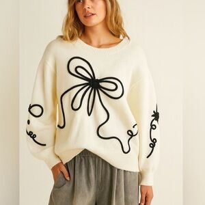 Chic Cream Sweater with Black Bow Accents